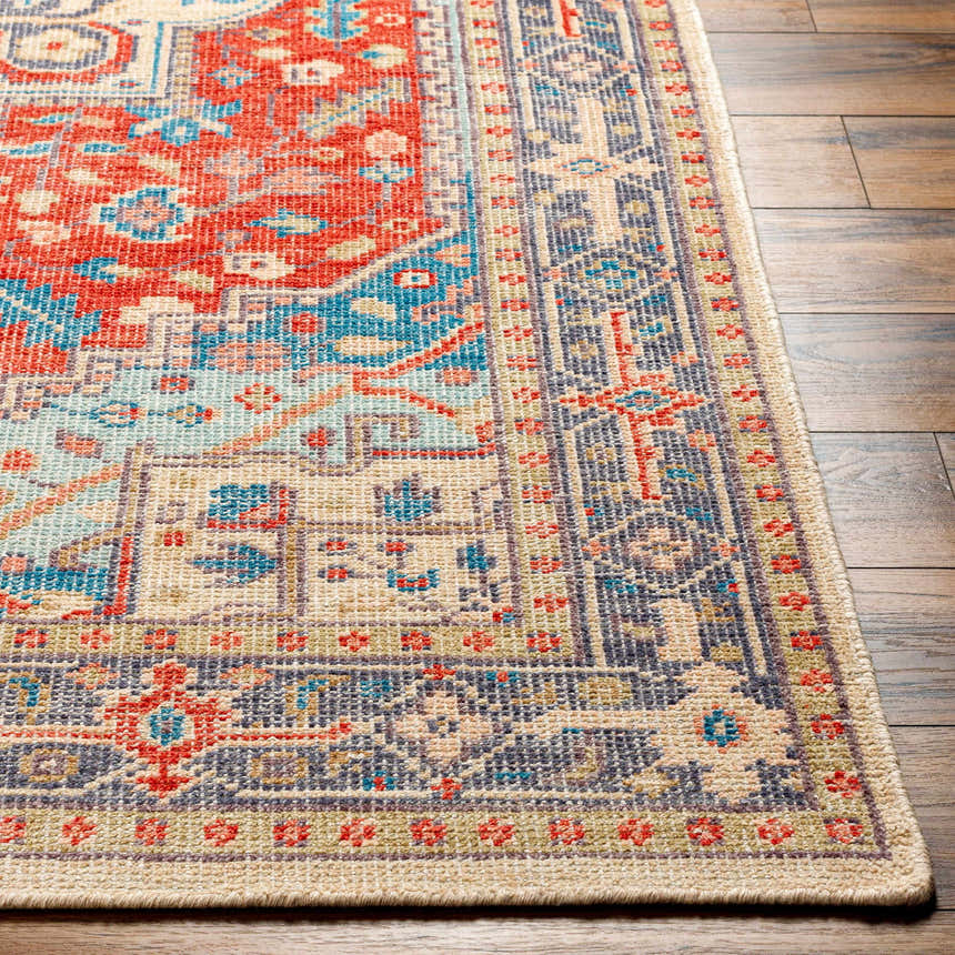 Close-up of the Oracabessa Premium Area Rug. Hand-knotted wool rug with a traditional Persian design in blue, red, and beige tones. Front