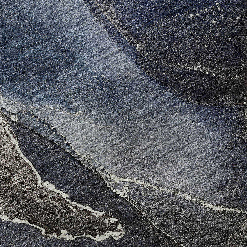 Close-up of the Dalyn Luxury Odyssey OY3 Blue Washable Area Rug, showing a textured blend of navy, light blue, and ivory.