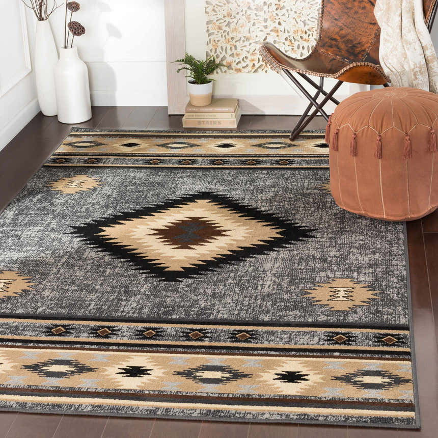 Living room scene with a Buckhaven area rug in brown, beige, and black with a Southwestern pattern. Roomscene-Rectangle