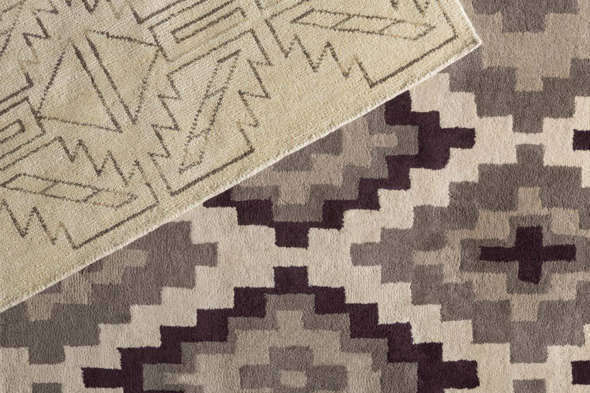 Close-up of the Pawhuska Area Rug. Features traditional geometric patterns in charcoal, peach, and cream tones. Hand-knotted wool texture. Styleshot