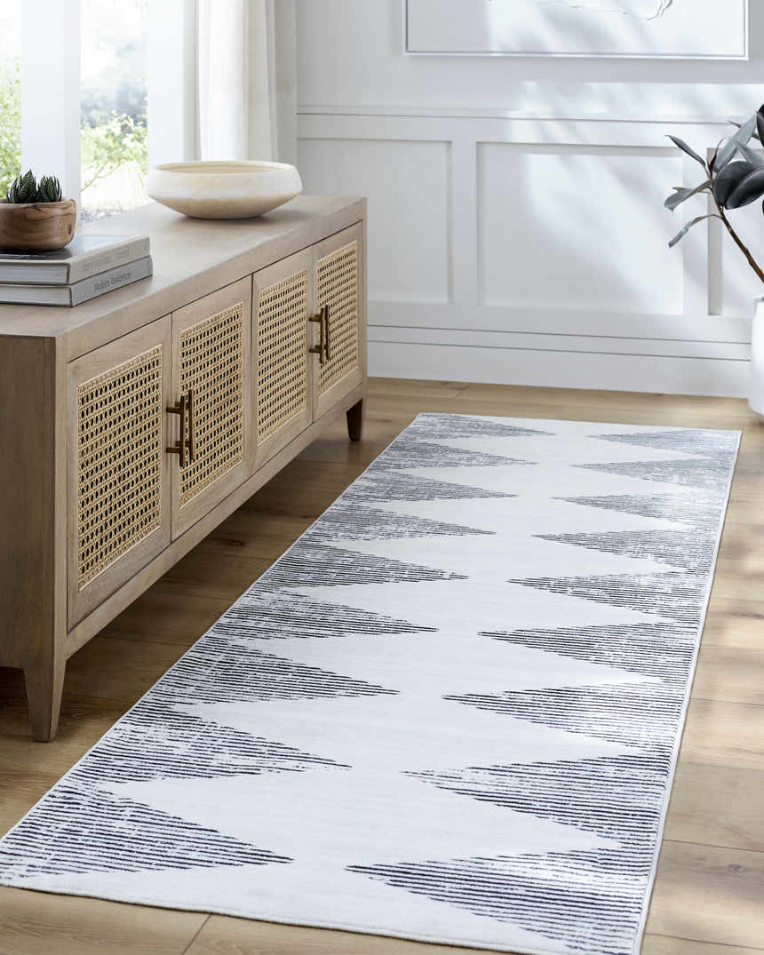 Living room scene with Prema Washable Area Rug runner in ivory and old lavender, wood cabinet, and light wood floors. Roomscene-Runner