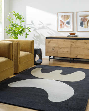 Contemporary living room with yellow armchairs and the Antoon Area Rug, a gray wool rug with a cream abstract design. Roomscene-Rectangle