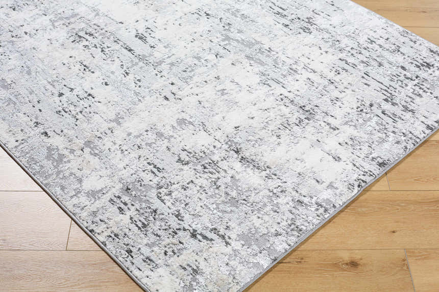 Close-up of the Avital Area Rug. Contemporary design in black, charcoal, gray, and white on a machine woven rectangle. Corner
