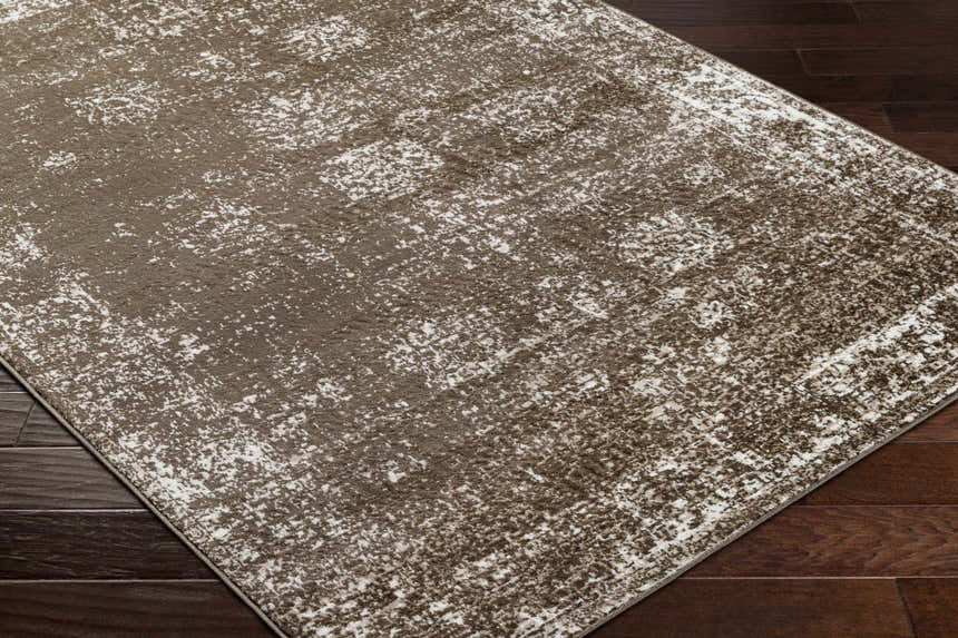 Close-up of the Quita Area Rug showing its charcoal, dark brown, and ivory abstract farmhouse design. Corner