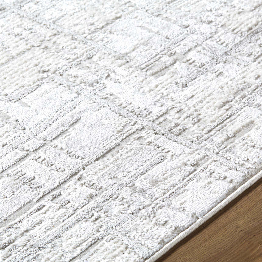 Close-up of the Antony Area Rug featuring a textured geometric pattern in cream, ivory, light gray, and white. Texture