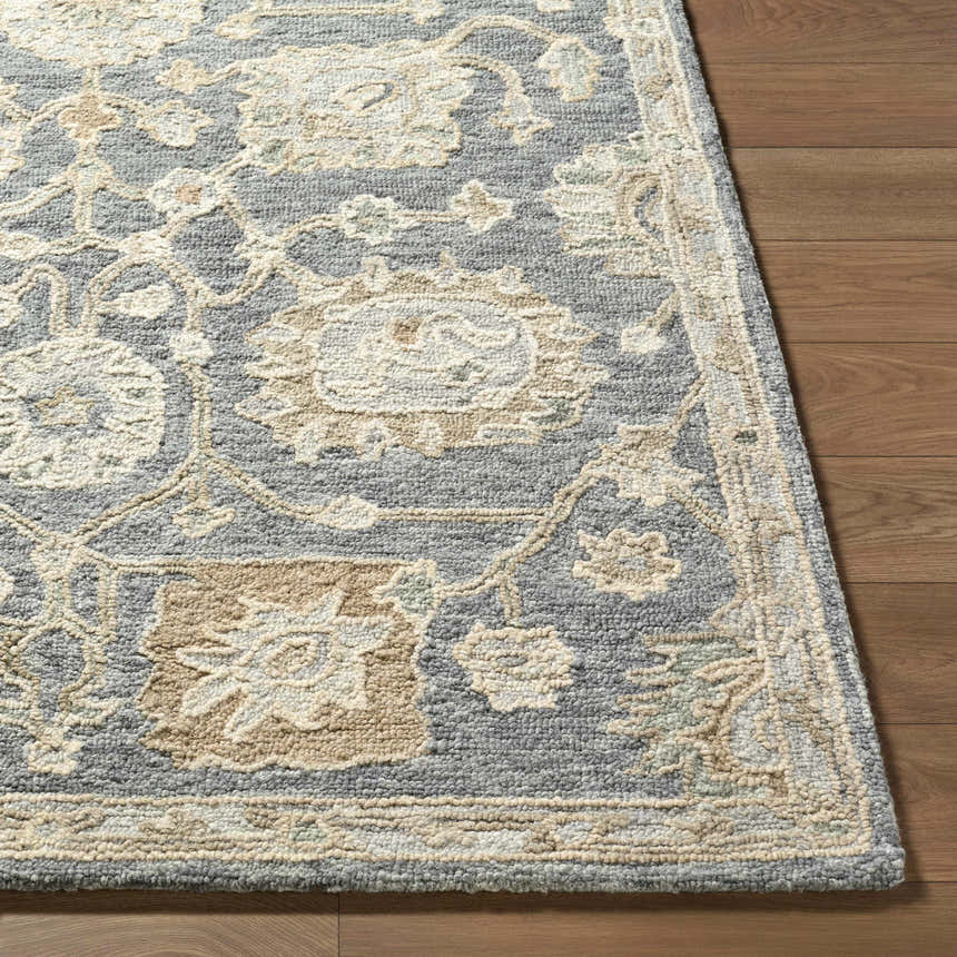 Close up of the Auryon Hand Tufted Oushak Wool Area Rug. Features off white and slate blue floral pattern on wool texture. Front