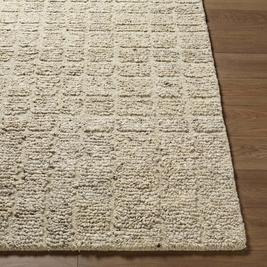 Close-up of the hand-tufted Asahel Ivory Area Rug showing wool texture and farmhouse style on wood floor. Front
