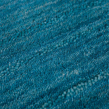 Close up of the textured Dalyn Rafia RF100 Cobalt Area Rug. Blue, light blue, and teal wool fibers.
