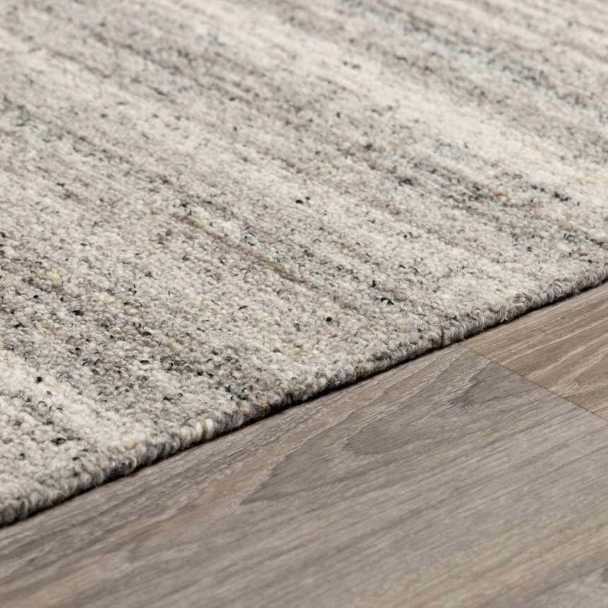 Close-up of the Capote Stone Gray Area Rug showing its wool texture, ash, charcoal, and stone gray colors. Pile