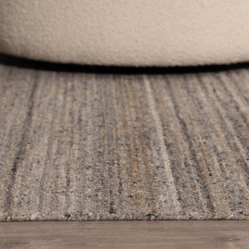 Close up of the hand tufted Capote Stone Gray Area Rug showing wool texture and subtle ash, charcoal, and ivory colors. Roomscene-Rectangle
