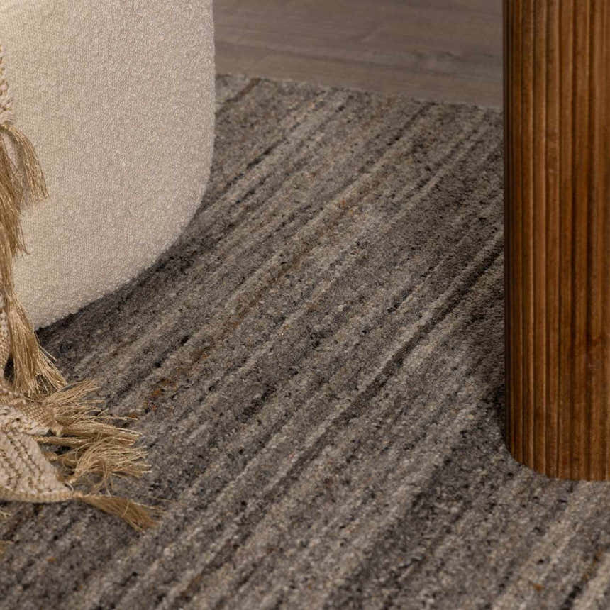 Close-up of the Capote Stone Gray Area Rug showing ash, charcoal, and ivory tones with a subtle striped pattern. Roomscene-Rectangle