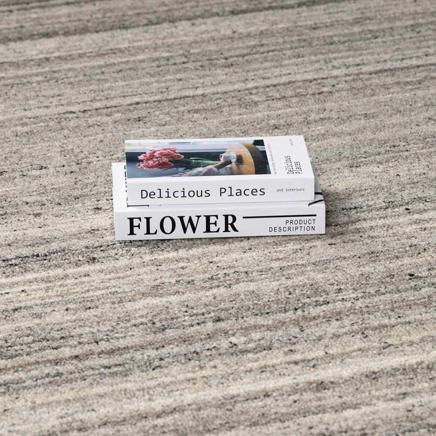 Close-up of the Capote Stone Gray Area Rug showing ash, charcoal, and ivory hues with a subtle horizontal pattern. Styleshot