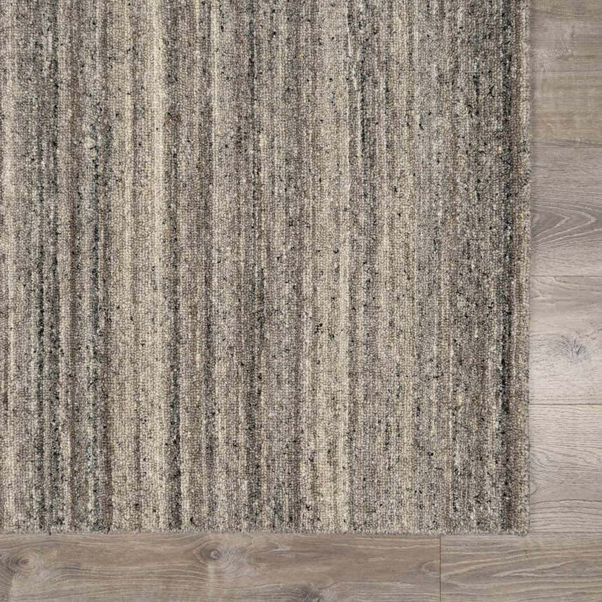 Close-up of the hand-tufted Capote Stone Gray Area Rug. Wool rug with ash, charcoal, ivory, and stone gray vertical stripes. Swatch