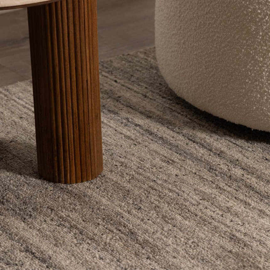 Close-up of the hand-tufted Capote Tan Area Rug showing its ash, charcoal, and taupe tones and wool texture. Roomscene-Rectangle