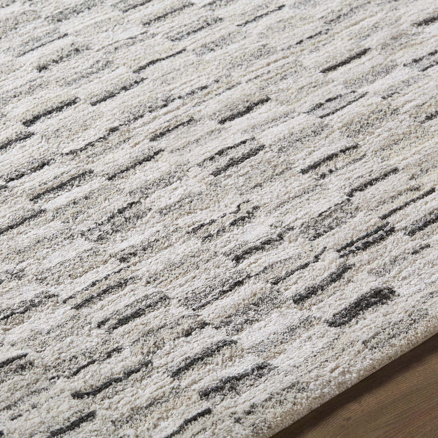 Close up of the Reece Luxe Rug, showing beige, cream, and black textured stripes. Texture