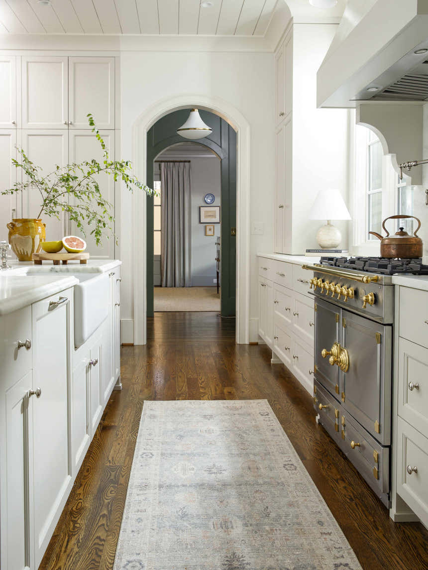 Bright kitchen with Marlene Damask Cream & Blue rug runner on hardwood floors. White cabinets and stainless steel range. Roomscene-Runner