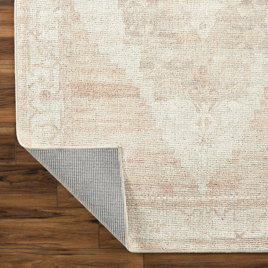 Close-up of the Luca Machine Woven Becki Owens x LIVABLISS BONC-2301 Area Rug, showcasing its dusty pink and ivory traditional pattern. Fold