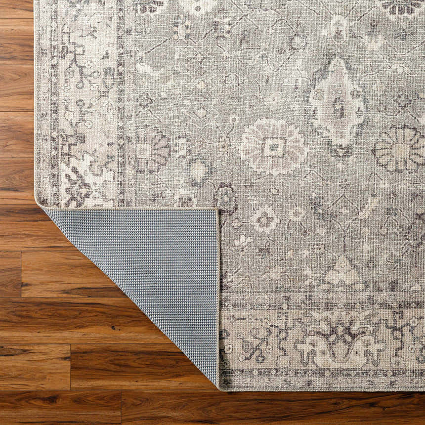 Close-up of Davina Becki Owens x LIVABLISS rug showing charcoal, gray, and taupe traditional floral pattern and non-slip backing. Back