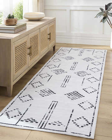 Entryway with a light wood console table and a white Shiva Washable Area Rug runner with black geometric patterns. Roomscene-Runner