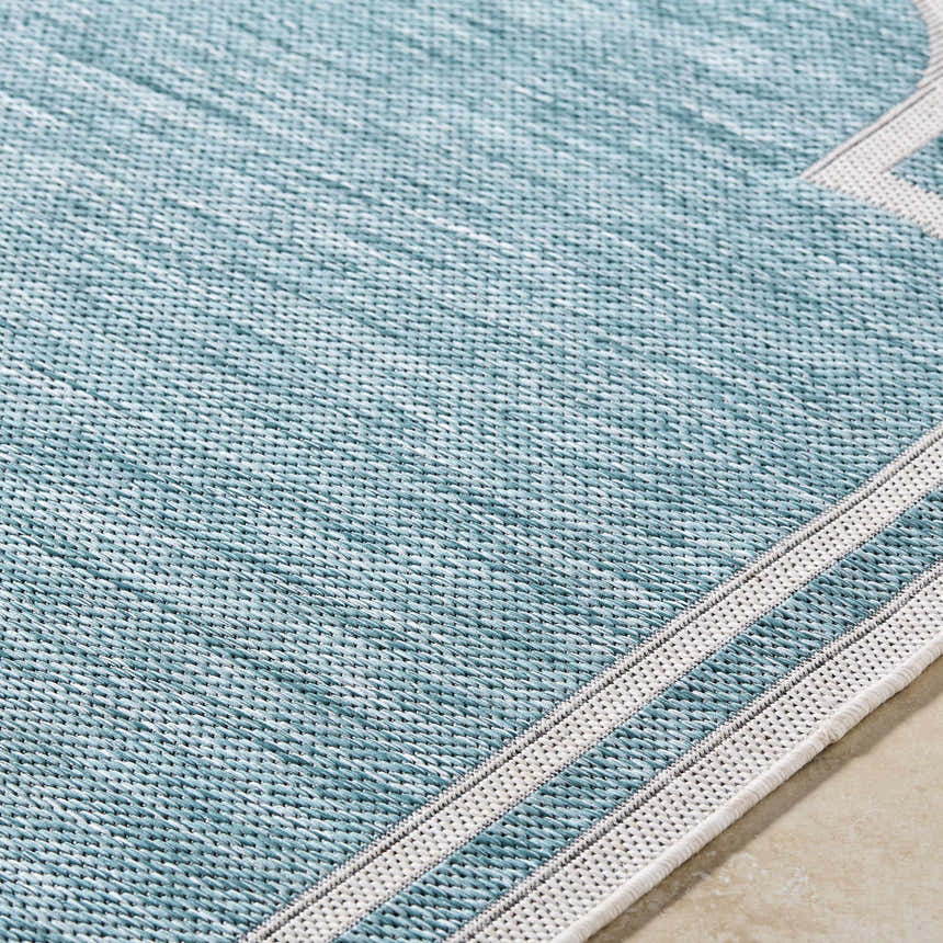 Close up of Arnola Light Blue Outdoor Rug showing woven texture and cream stripes. Texture