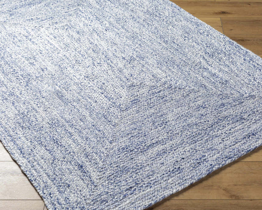 Close-up of the hand-woven Kenyi Navy Area Rug showing its navy and white color and textured, contemporary design. Corner