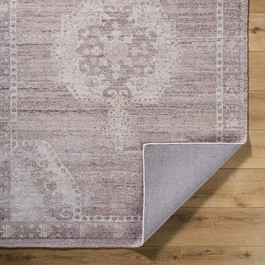 Close-up of the Alafin Area Rug. Hand-tufted polyester rug in blush, cream, dusty rose, and mauve with traditional farmhouse design. Fold