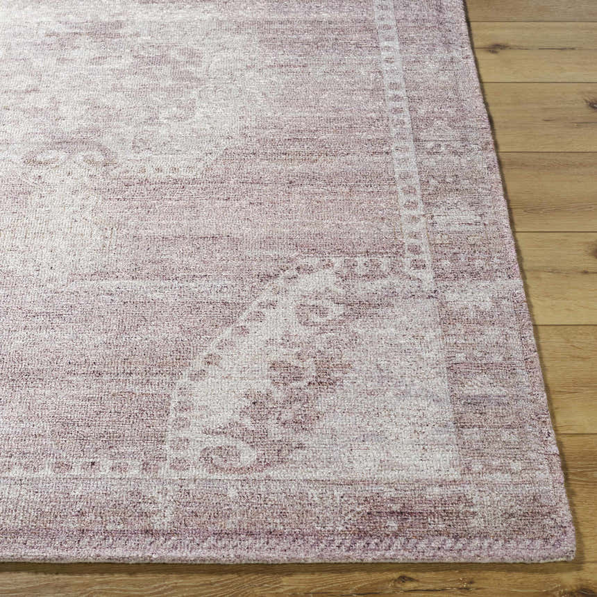 Close-up of the hand-tufted Alafin Area Rug. Features blush, cream, and mauve tones with a traditional pattern. Front