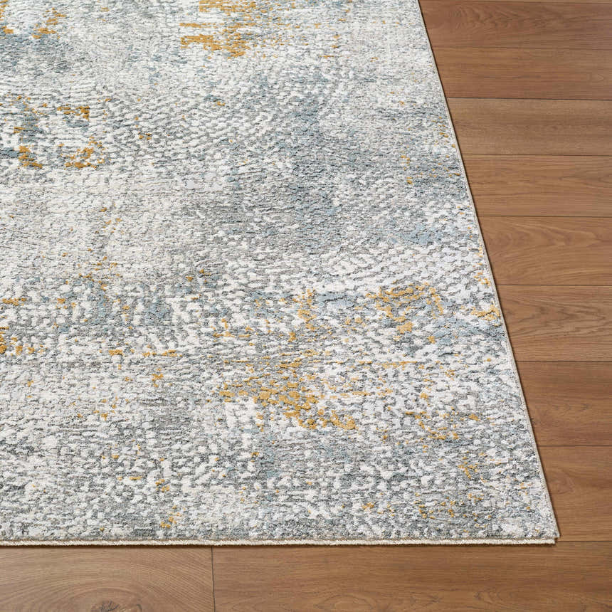 Close-up of the Fleur Textured Rug with Fringes. The rug has gray, white, and gold tones with a textured, contemporary design. Front