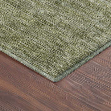Close-up of the Aloe Dalyn Luxury Soft Essentials rug showing texture and color on a wood floor.