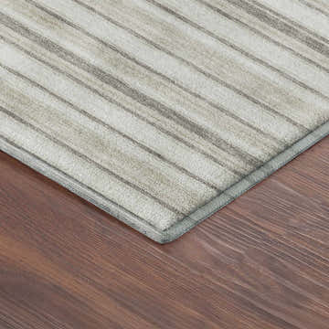 Close-up of Dalyn Luxury Soft Essentials SE2 Linen Washable Area Rug. Beige rug with subtle gray stripes on wood floor.
