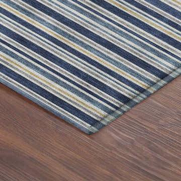 Close-up of Dalyn Luxury Soft Essentials Navy Washable Area Rug. Features a striped pattern in navy, gray, white, and gold.