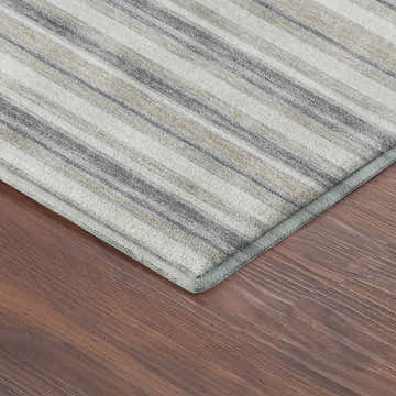 Close-up of Dalyn Luxury Soft Essentials SE2 Silver Washable Area Rug with gray and beige stripes on wood floor.