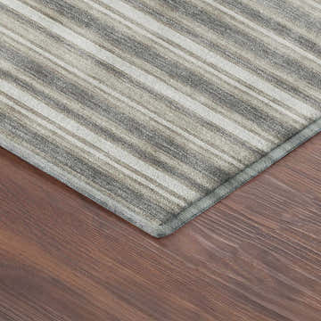 Close-up of Dalyn Luxury Soft Essentials SE2 Taupe rug showing ivory and gray stripes on dark wood floor.