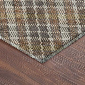 Close-up of Dalyn Luxury Soft Essentials Earth rug's plaid pattern in sandstone, brown, and cream on wood floor.