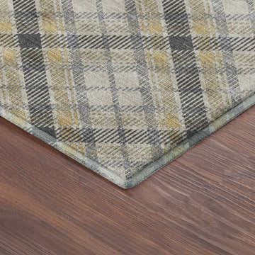 Close-up of the Dalyn Luxury Soft Essentials Granite rug. Gray, gold, and cream plaid pattern on a wood floor.