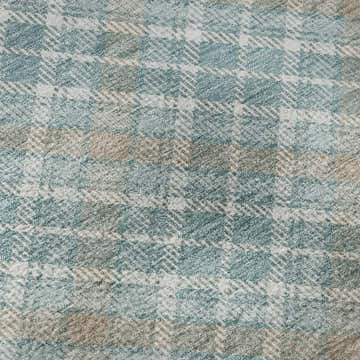 Close-up of the Dalyn Luxury Soft Essentials SE3 Teal Washable Area Rug, showing a teal, white, and tan plaid pattern.
