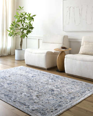 Living room scene with a light blue and gray Irida Area Rug, white chairs, and wood floors. Roomscene-Rectangle