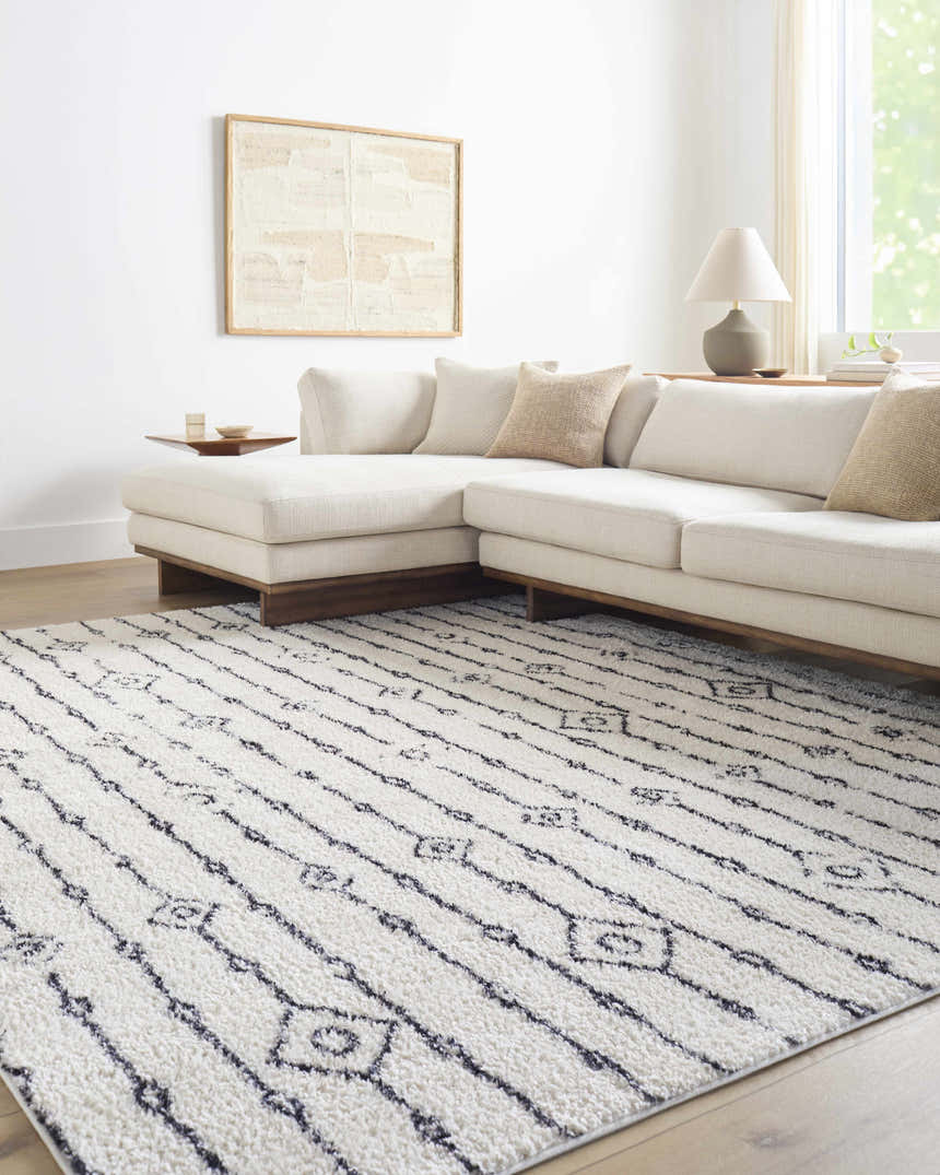 Living room scene with a Demi Beige Washable Area Rug, white sectional sofa, and neutral decor. Roomscene-Rectangle