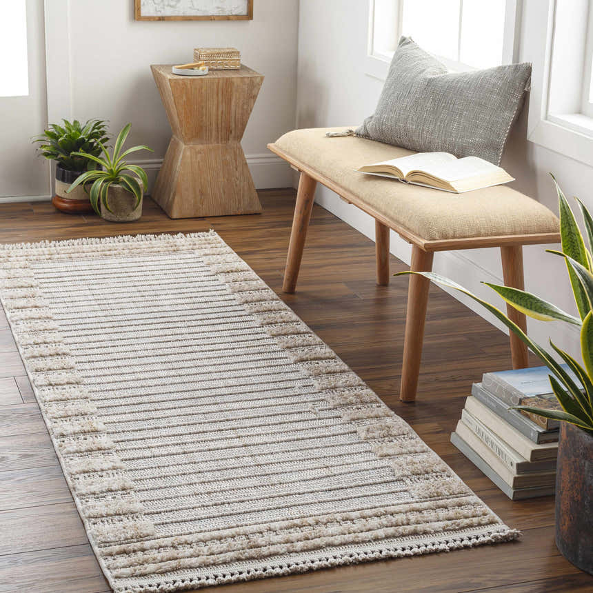 Entryway with Sulak Cream Area Rug runner, wood bench, plants, and books for a cozy, Scandinavian-inspired space. Roomscene-Runner