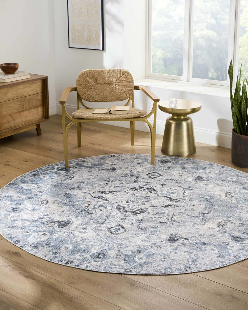 Living room scene with round Ankti Blue Washable Area Rug, woven chair, wood dresser, and gold side table. Roomscene-Round