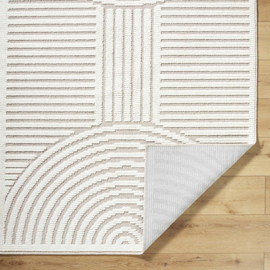 Close up of the Deron Ivory 3D Rainbow Washable Rug. Off white rug features a geometric rainbow design and a light gray backing. Fold