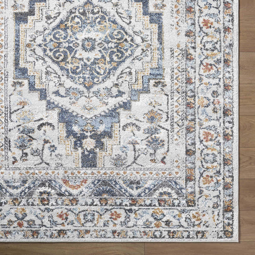 Close up of the Paula Off White Area Rug showing its traditional charcoal, light brown, and mustard pattern. Corner