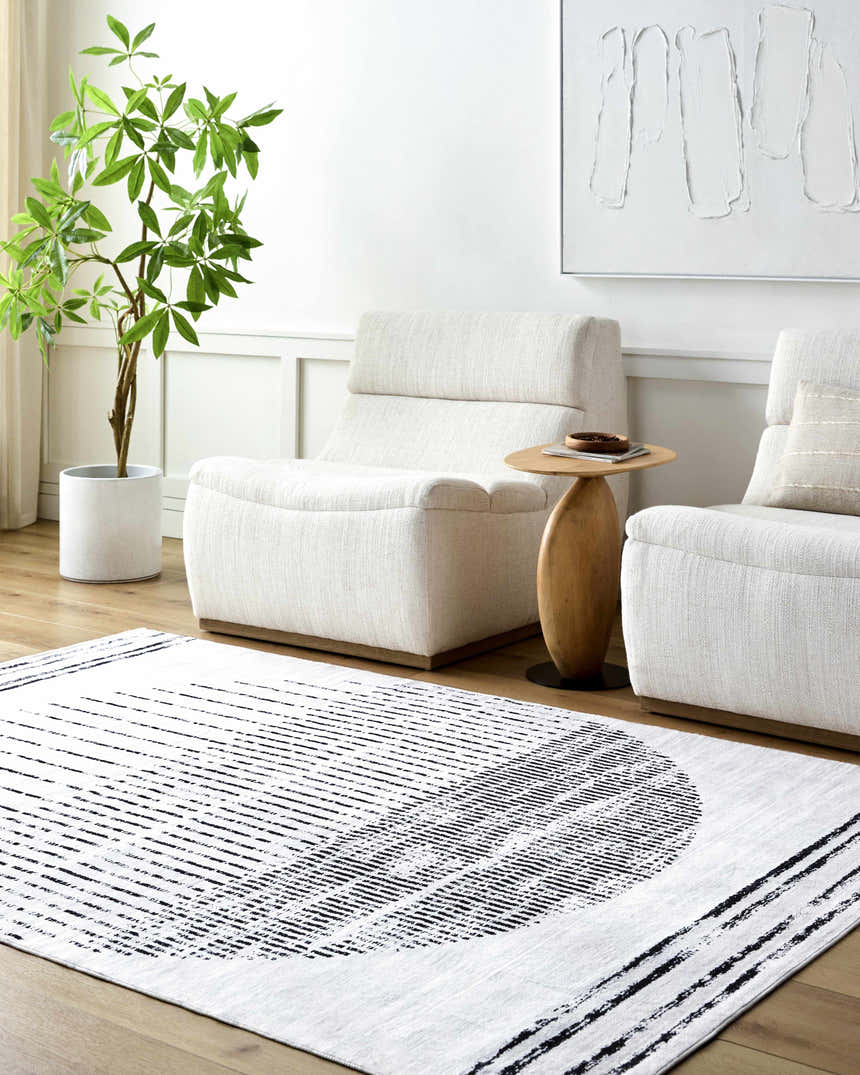 Living room scene with white chairs and Sabia Washable Area Rug. The rug has a silver gray and white geometric pattern. Roomscene-Rectangle