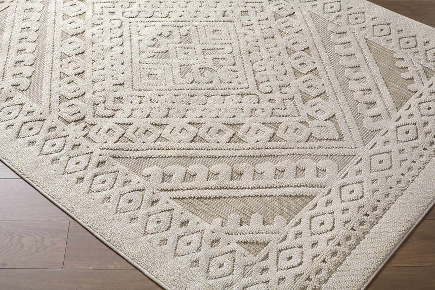 Close-up of the Hibah Bone Area Rug showing a contemporary geometric pattern in beige and bone on a wood floor. Corner