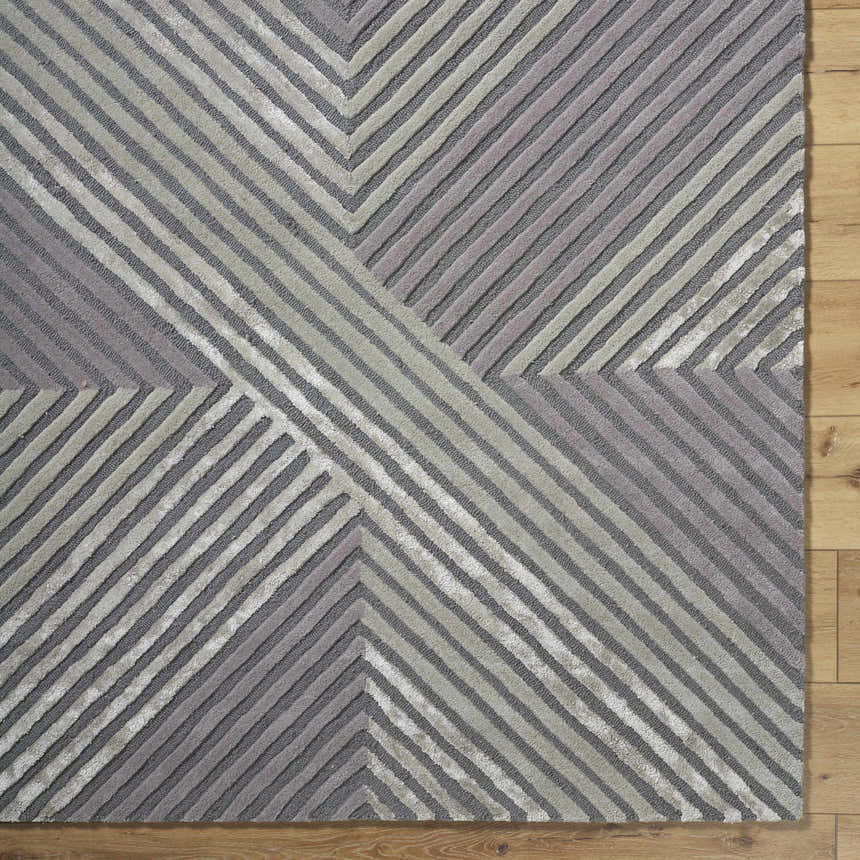Close up of the hand tufted Juan Area Rug featuring a contemporary geometric stripe pattern in beige, gray, and taupe. Corner