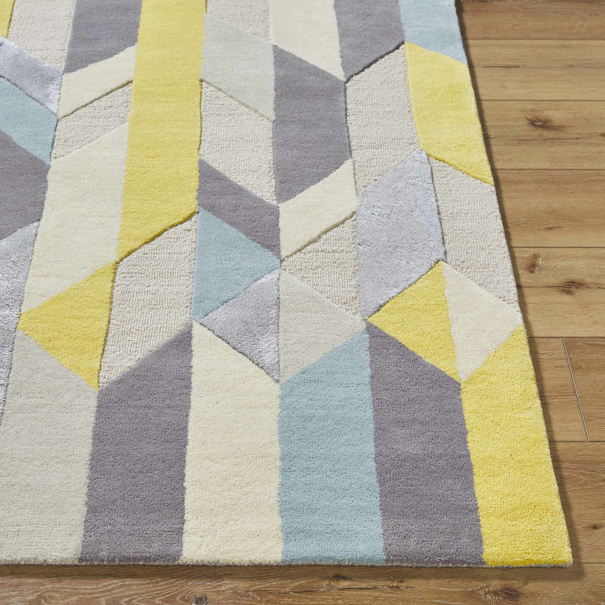 Close-up of the hand-tufted Zoie Area Rug. Contemporary geometric design in camel, gray, lambswool, and saffron. 70% wool rug. Front