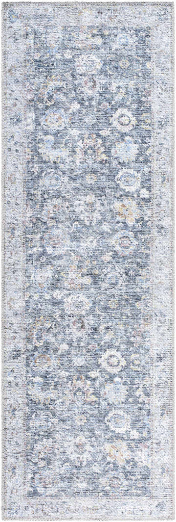 Close-up of the Napeu Washable Area Rug. Denim, light gray, and silver floral pattern with a traditional farmhouse style. Design-Runner-27710