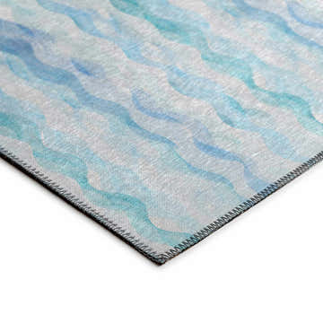 Close-up of Dalyn Seabreeze SZ16 Denim Washable Area Rug. Features a wavy, watercolor-like pattern in denim, teal, and navy.