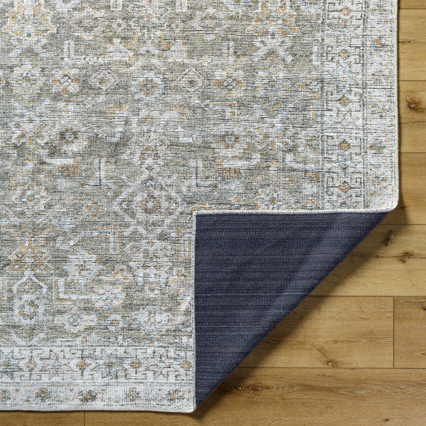 Close-up of the Tisha Washable Area Rug, a farmhouse style rug in gray, tan, and silver gray on a wood floor. Fold