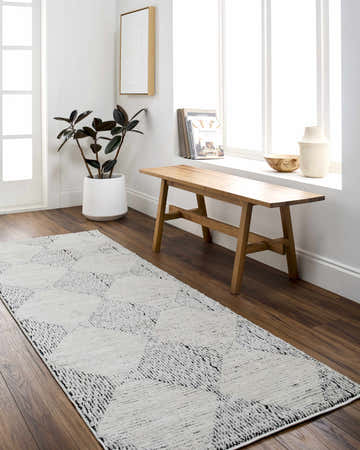 Entryway with a black and ivory Truda Area Rug runner, wood bench, and indoor plant. Roomscene-Runner